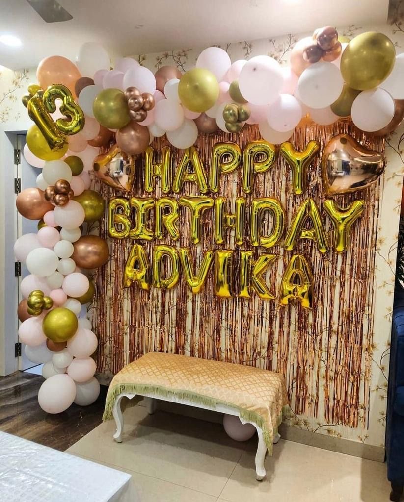Premium Golden and Rose Gold Birthday Decoration featuring a stylish balloon garland in gold, rose gold, white and pastel shades, rose gold fringe backdrop, golden Happy Birthday foil letters, custom name and custom age number. The decoration is fully customizable according to your choice of colours, name, age and theme, perfect for birthday celebrations and special occasions in Uttam Nagar Delhi NCR.